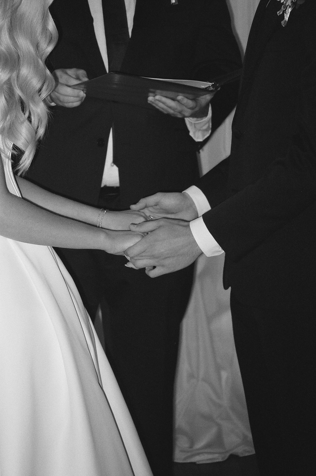 A bride and groom stand with an officiant during their wedding ceremony at Stanly Hall Ballroom