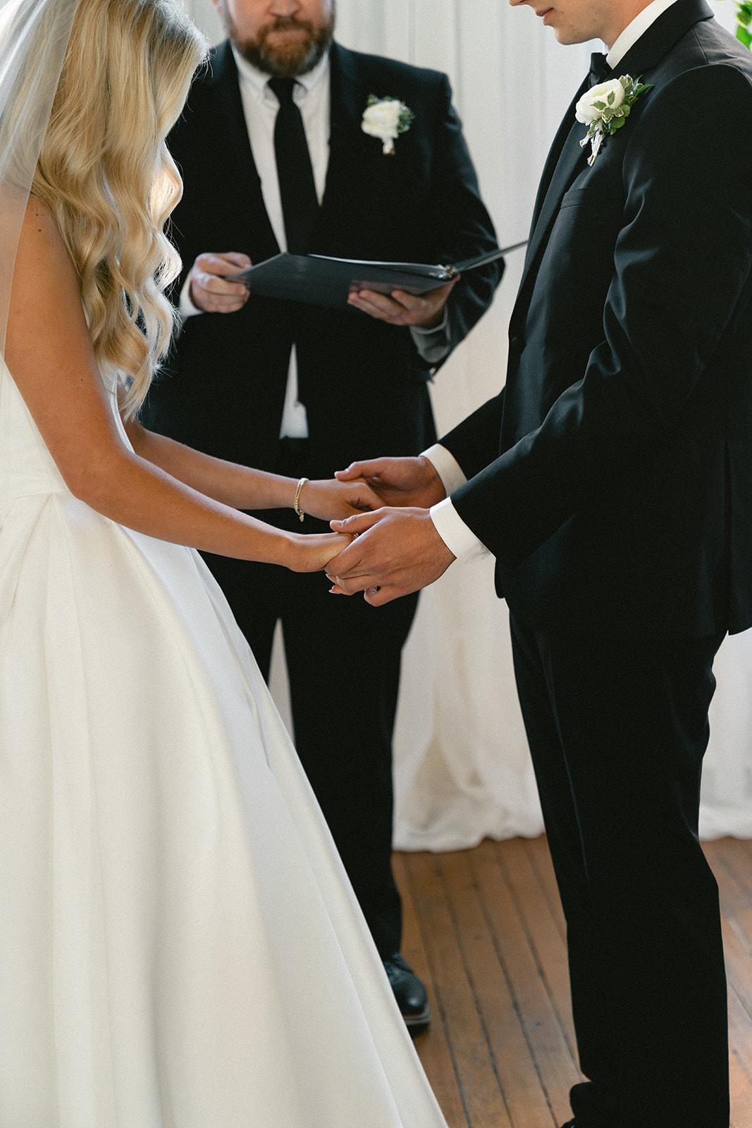A bride and groom stand with an officiant during their wedding ceremony at Stanly Hall Ballroom