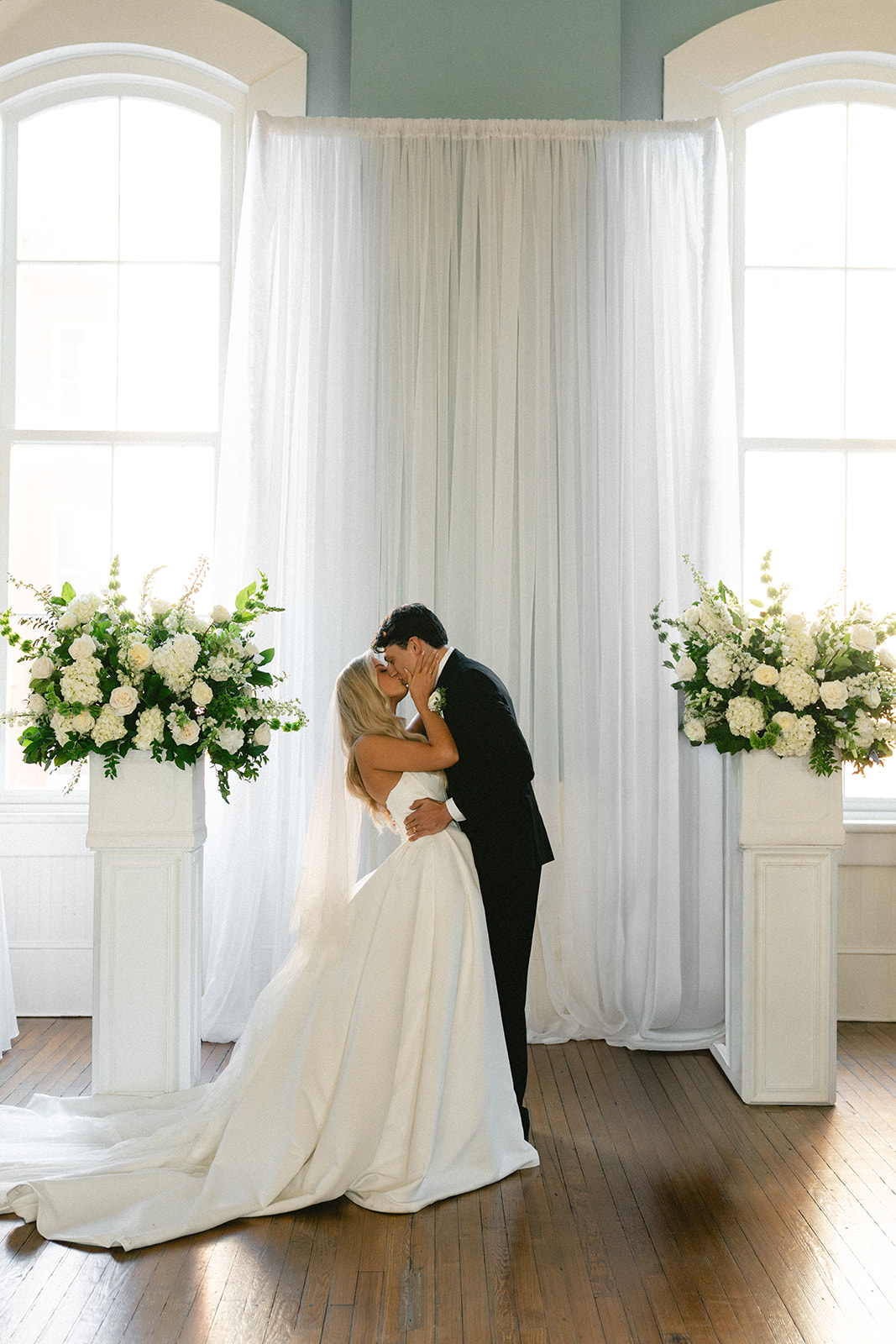 A bride and groom stand with an officiant during their wedding ceremony at Stanly Hall Ballroom