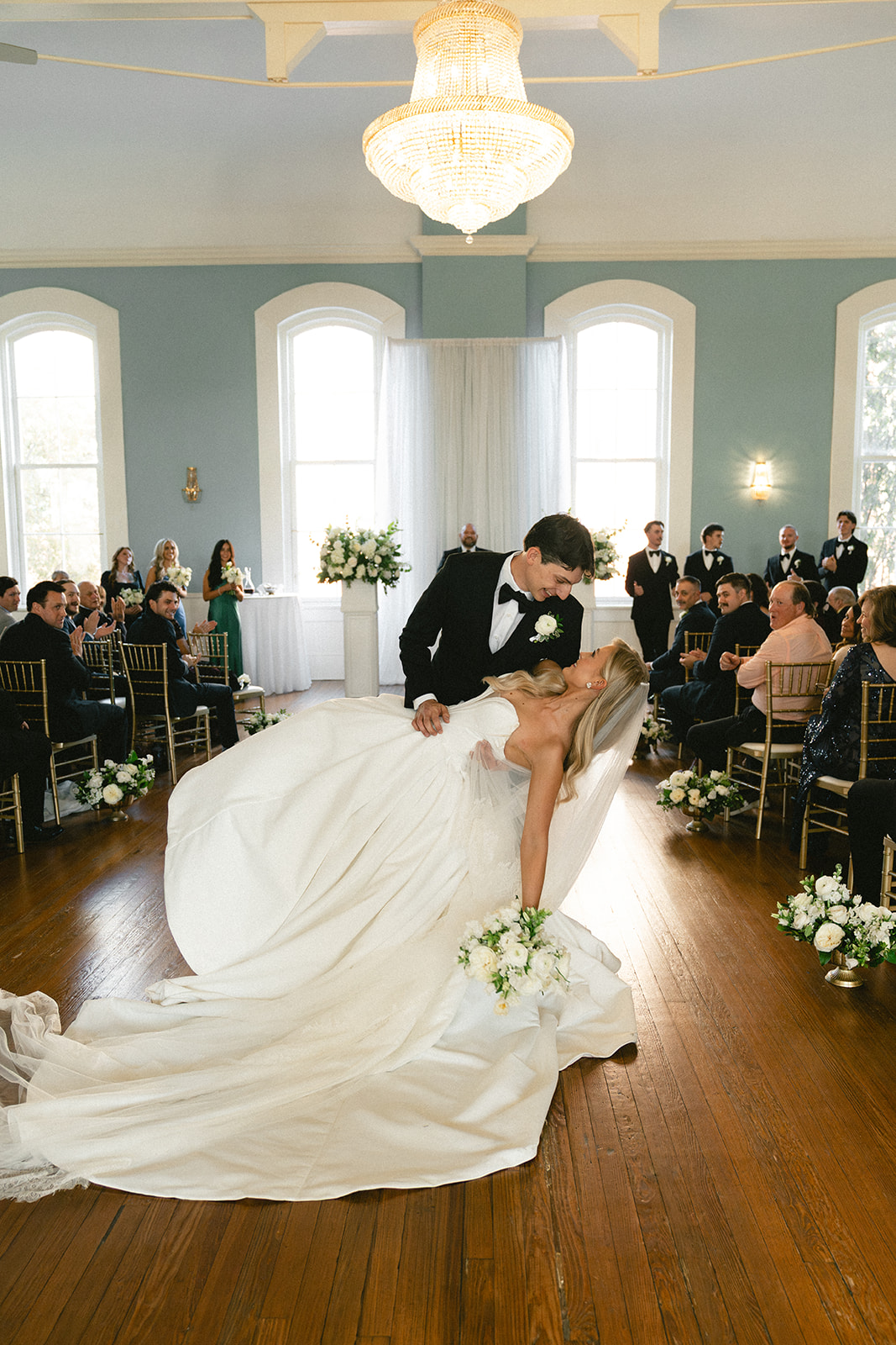 A bride and groom stand with an officiant during their wedding ceremony at Stanly Hall Ballroom