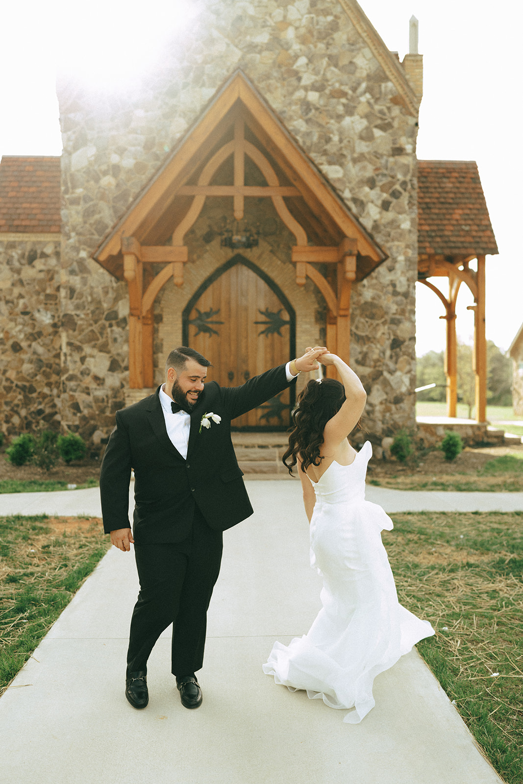 A bride and groom stand at the altar with an officiant in a stone chapel, surrounded by seated guests at the little chapel at haven ridge a wedding venue in North Carolina