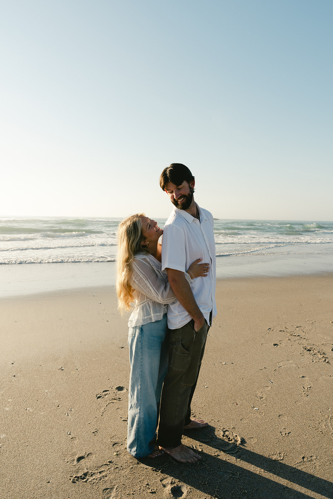 Couple takes beach engagement photos on the East Coast. Taken by a North Carolina engagement photographer