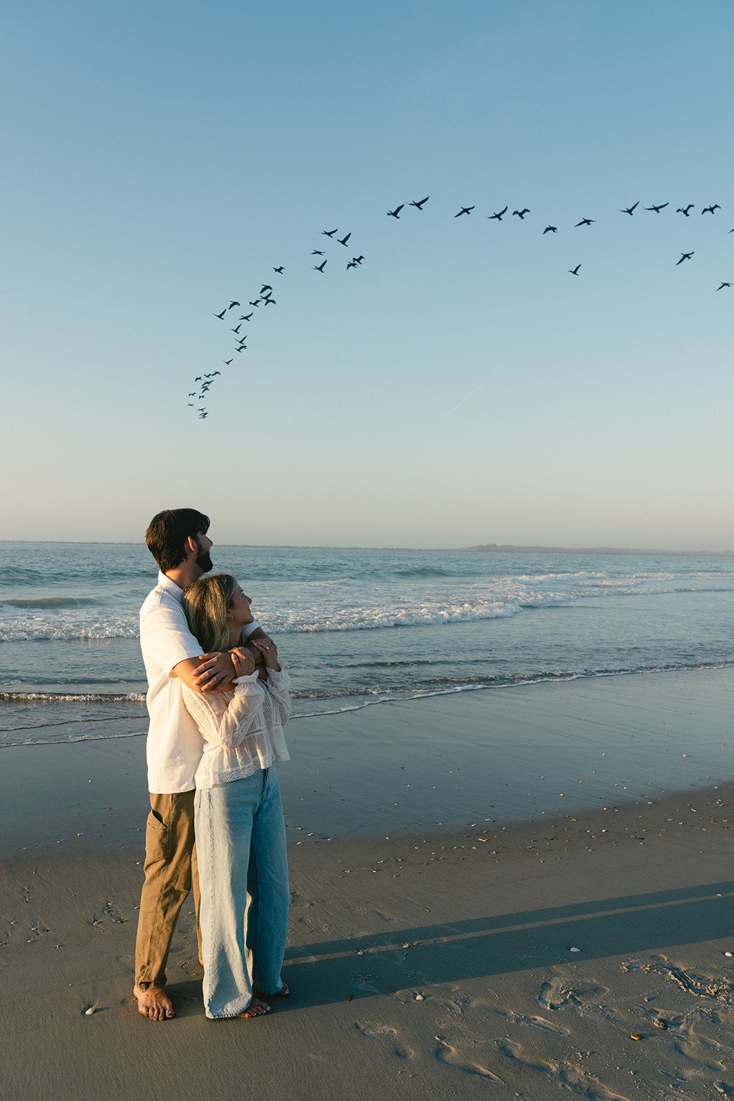Couple takes beach engagement photos on the East Coast. Taken by a North Carolina engagement photographer